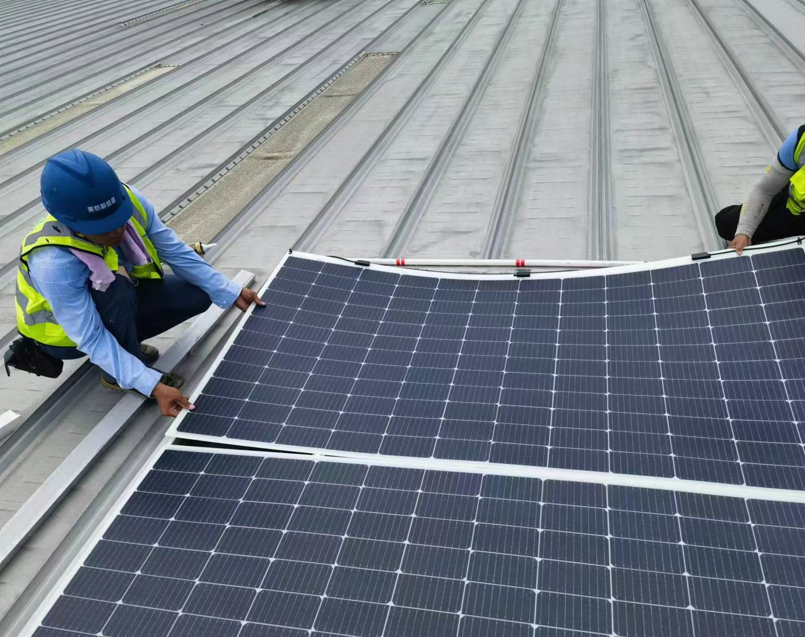 Workers installing the Sunman Solar Panels, a glass-free, lightweight & flexible solar panel on the roof of a CapitaLand property in China 